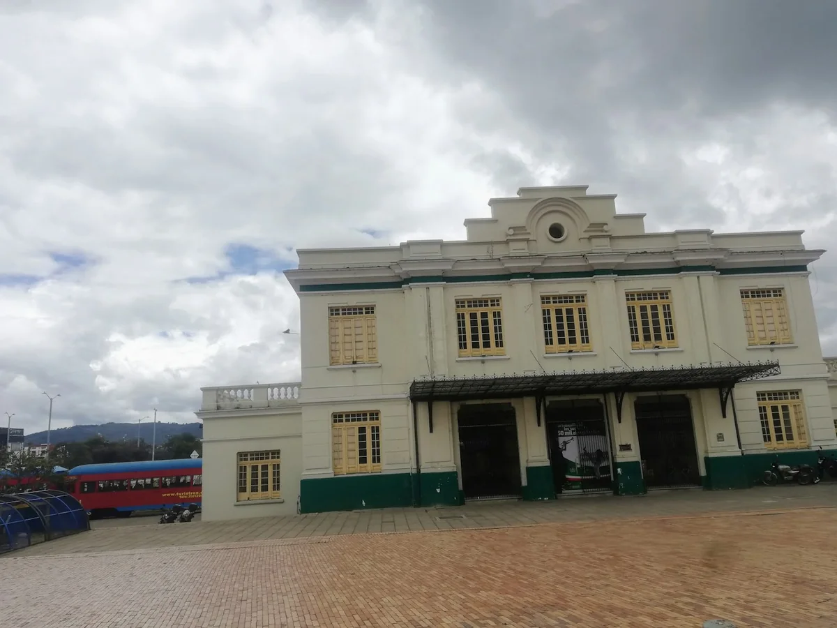 The red Turistren tourist train parked beside the historic Zipaquirá railway station building
